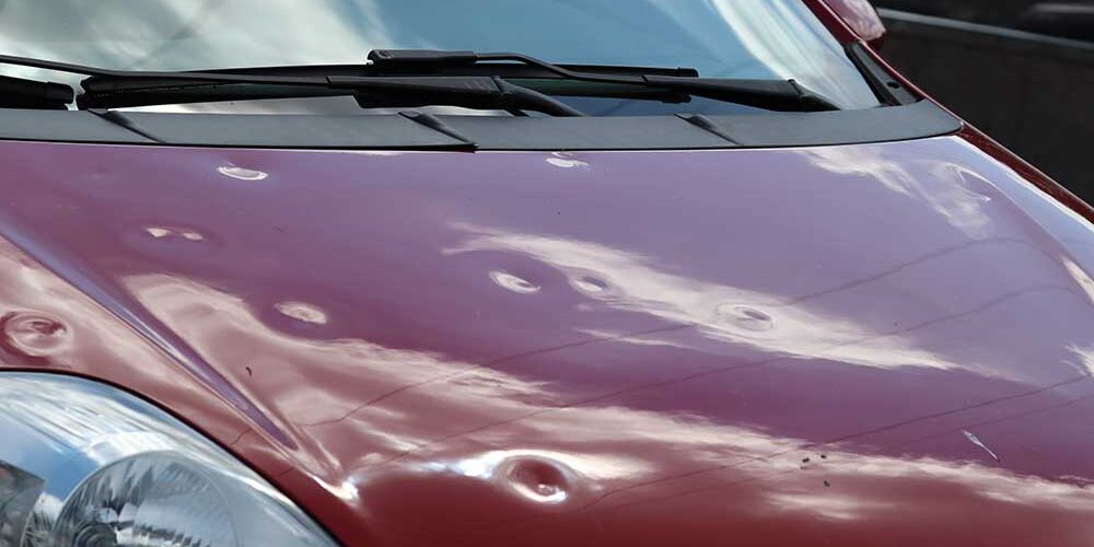 car with dents on hood